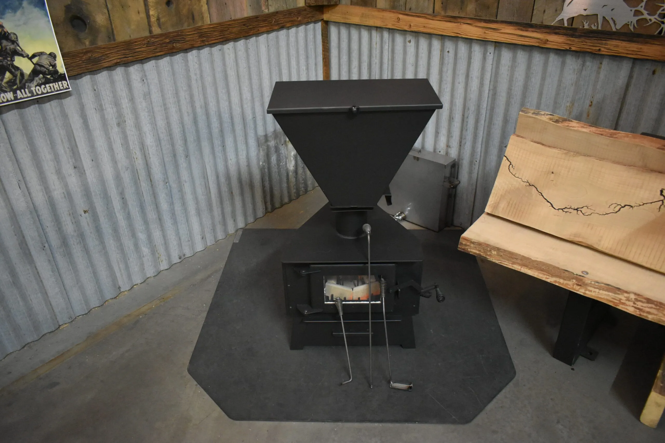 Mini Me non-electric pellet stove installed in a metal-walled workshop