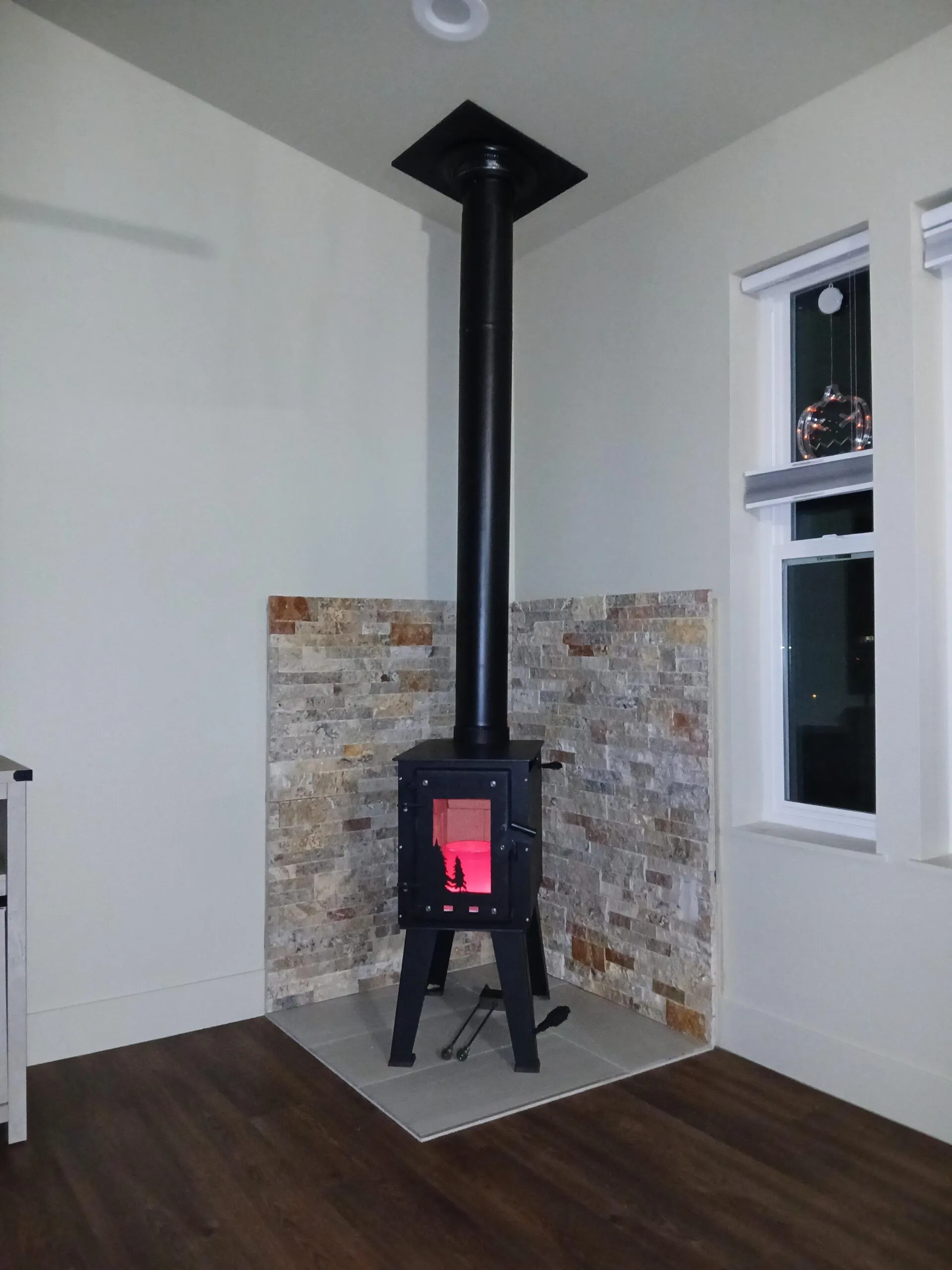 Steelhead small wood stove installed with corner heat shields in a home